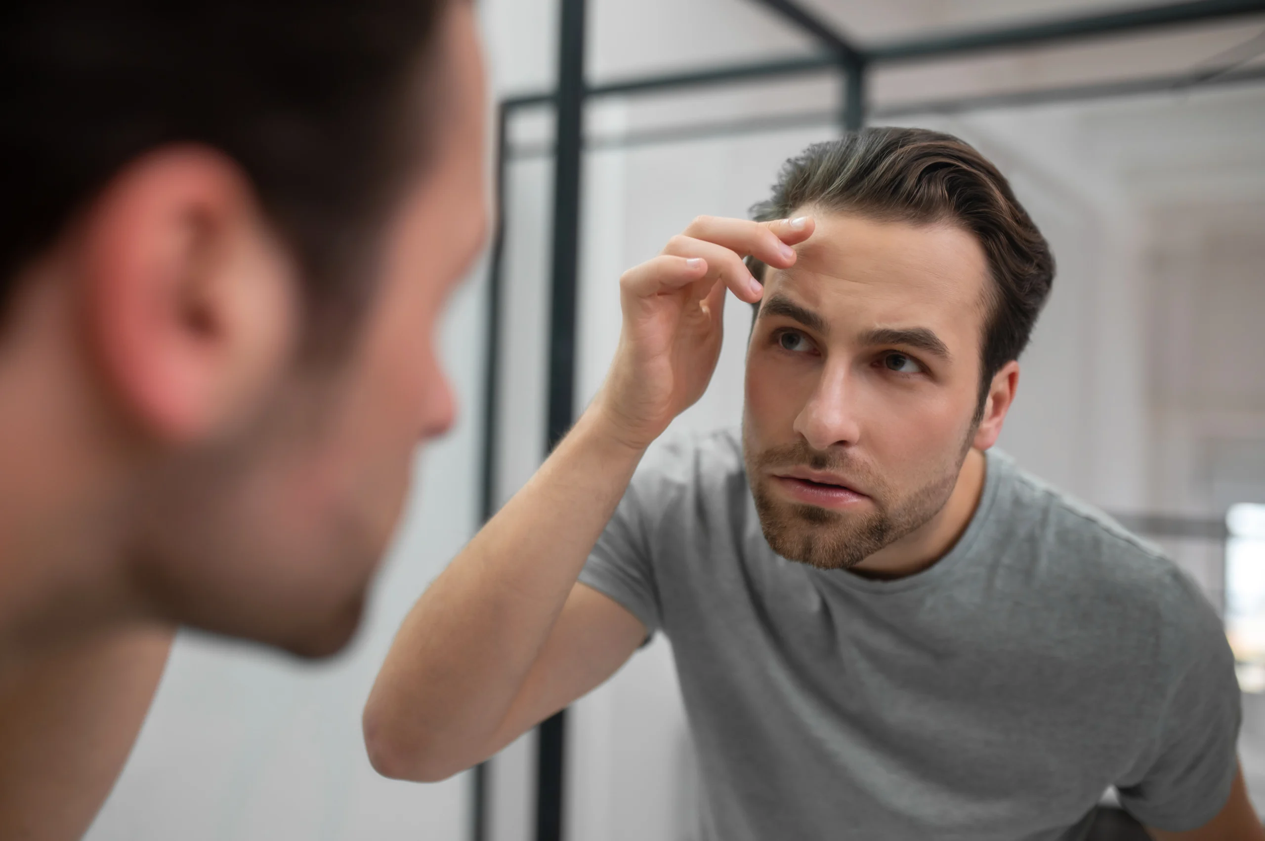 Patient examining restored hair density at the frontal hairline after a successful hair transplant UK.