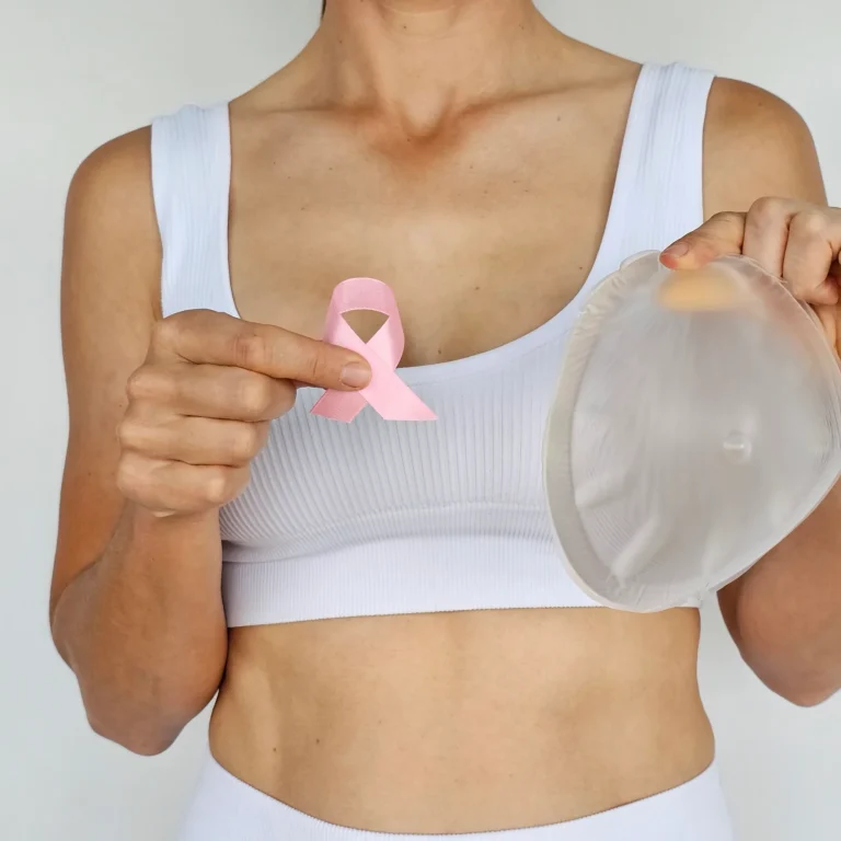 woman-holds-silicone-breast-implant-pink-ribbon-symbolize-breast-cancer-awareness